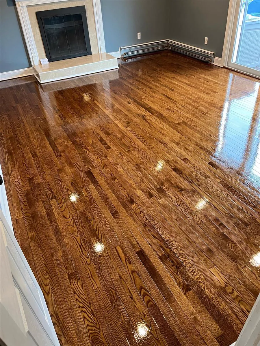 Refinished oak strip floor reflecting the light from a window